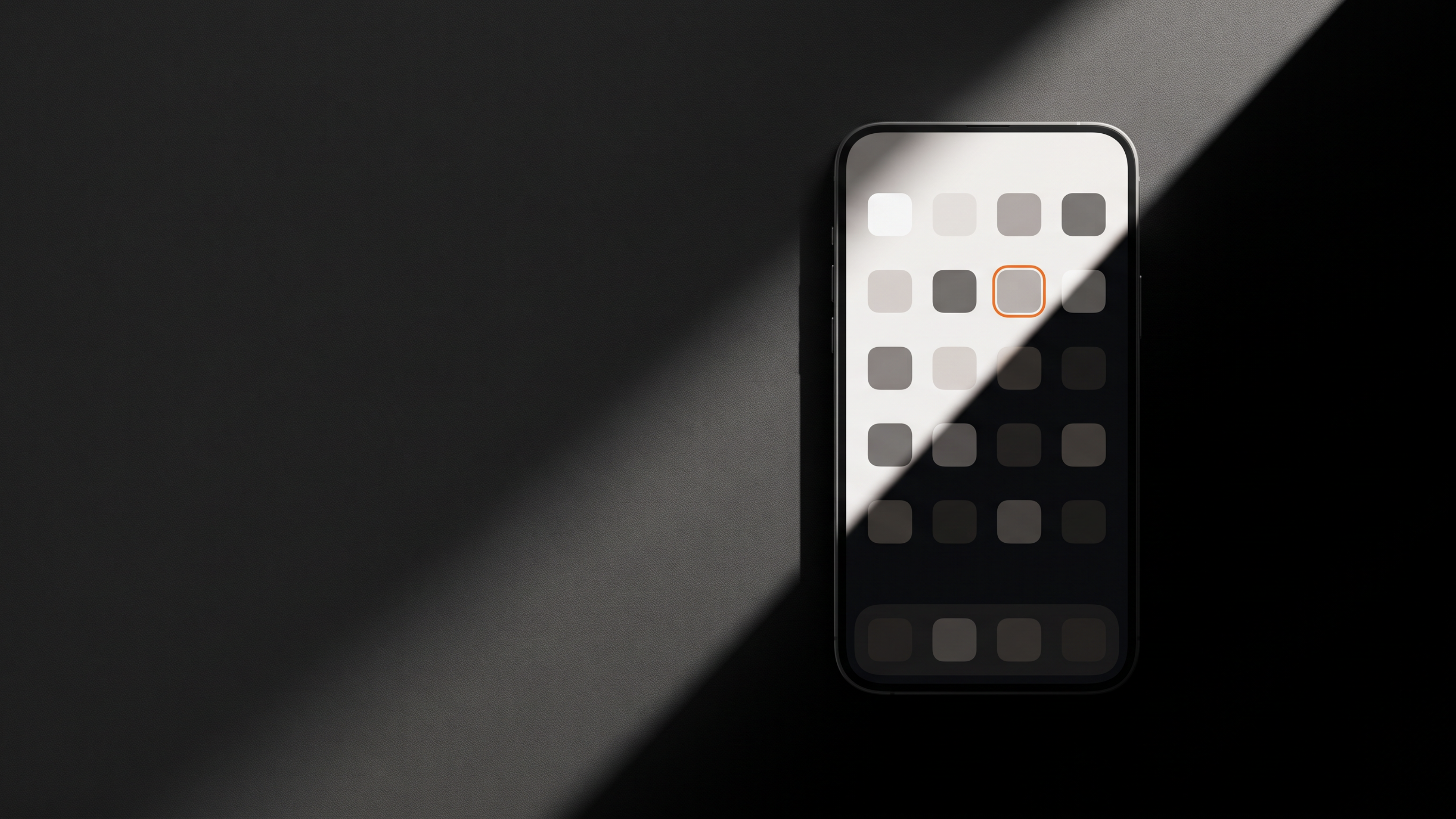 A phone home screen half in light and half in shadow